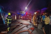 Anggota bomba berusaha memadamkan kebakaran rumah berkenaan. 