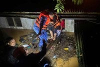 Anggota APM Gua Musang membantu penduduk yang terkesan dengan banjir berpindah ke kawasan selamat. - FOTO: APM