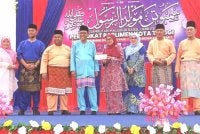 Mohamed Khaled (empat dari kiri) pada Majlis Sambutan Maulidur Rasul di Dewan Besar Felda Air Tawar 2 pada Ahad.