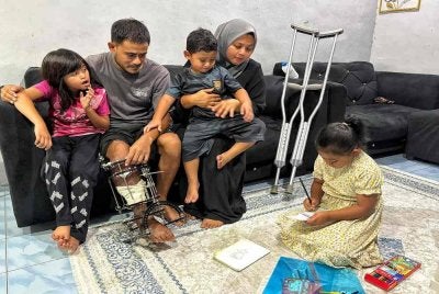 Kamal Ridzuan bersama keluarganya yang kini hanya bergantung kepada pendapatan penjual burger yang diusahakan isterinya, Nurma Lissa.