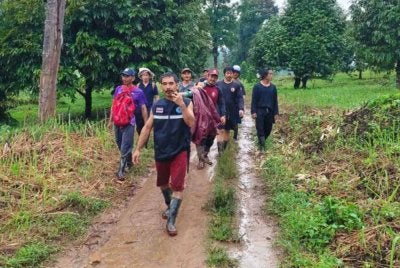 Jiran mengusung wanita terlantar berusia 90 tahun sejauh 9km dalam hujan lebat bagi membolehkannya ke bank. Foto: Facebook