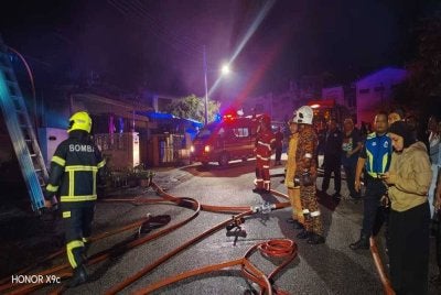 Anggota bomba berusaha memadamkan kebakaran rumah berkenaan. 