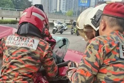 Anggota bomba sedang menjalankan kerja-kerja mengeluarkan mangsa yang tersepit.