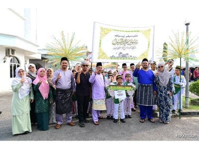Manndzri (dua, kanan) bersama kakitangan dan murid dari Sekolah Kebangsaan Felda Pengeli Timur yang menyertai perarakan Sambutan Maulidur Rasul di Masjid Al-Husna Bandar Tenggara, pada Ahad.