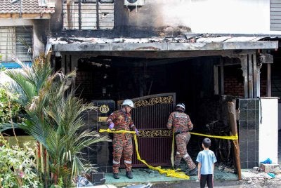 Anggota Jabatan Bomba dan Penyelamat Malaysia (JBPM) menjalankan tugas di lokasi kejadian selepas pasangan suami isteri warga emas dan cucu mereka maut dalam kebakaran membabitkan sebuah rumah teres dua tingkat di Persiaran Desa Tambun 4, Taman Desa Tambun di sini, awal pagi Ahad. Foto Bernama 