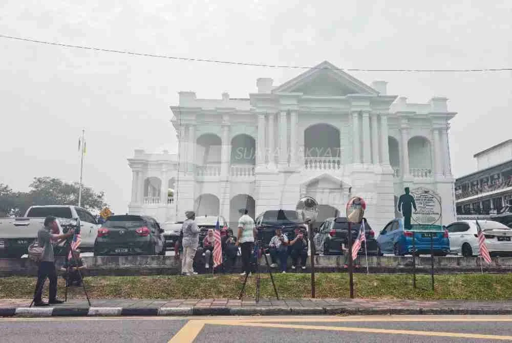 Pengamal media berkumpul di hadapan Wisma Negeri.