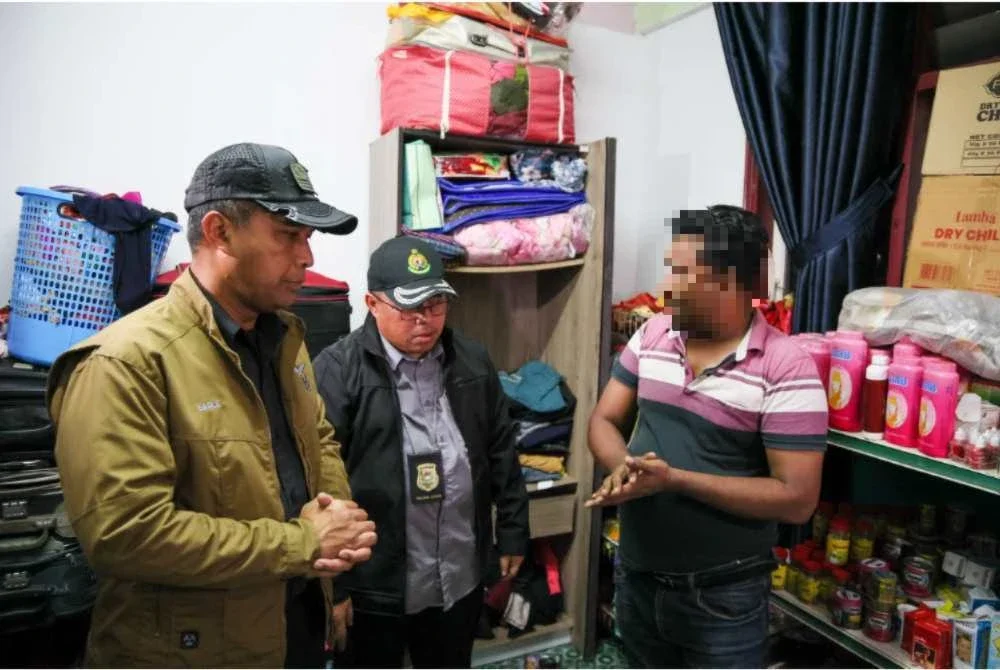 Lokman Effendi (kiri) ketika memeriksa sebuah kediaman dalam operasi penguatkuasaan di Flat Sri Kolam, Kuala Terengganu, awal pagi Isnin.