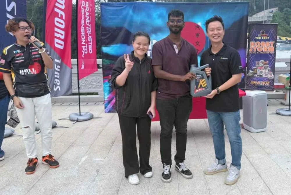 Pembantu Pengurus Pemasaran Aisin Malaysia, Jyun Siah ( kanan) menyampaikan hadiah cabutan bertuah berupa minyak pelincir premium.