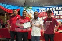 Amirudin (dua dari kanan) menyampaikan sijil penghargaan kepada ahli PKR. 