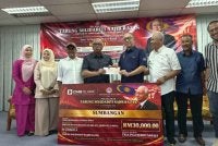 Mohd Zolkafly (empat dari kanan) menyerahkan cek bernilai RM30,000 sebagai sumbangan UMNO Bahagian Sungai Siput kepada Tabung Solidariti Najib sempena Majlis Pelancaran Tabung Solidariti Najib Razak Peringkat UMNO Bahagian Sungai Siput di Wisma UMNO Sungai Siput pada Isnin.