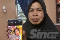 Mahani menunjukkan gambar cucunya, Puteri Nur Afiyah Qalesya yang ditemui lemas selepas dicampakkan bapa saudaranya ke sungai.
