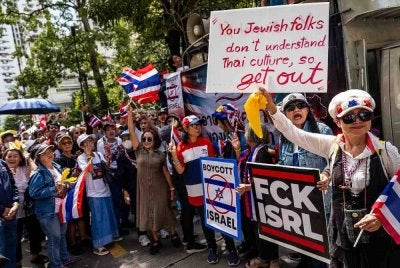 Penunjuk perasaan mengadakan himpunan sambil membawa plakad di luar Kedutaan Israel di Bangkok. Foto: AFP