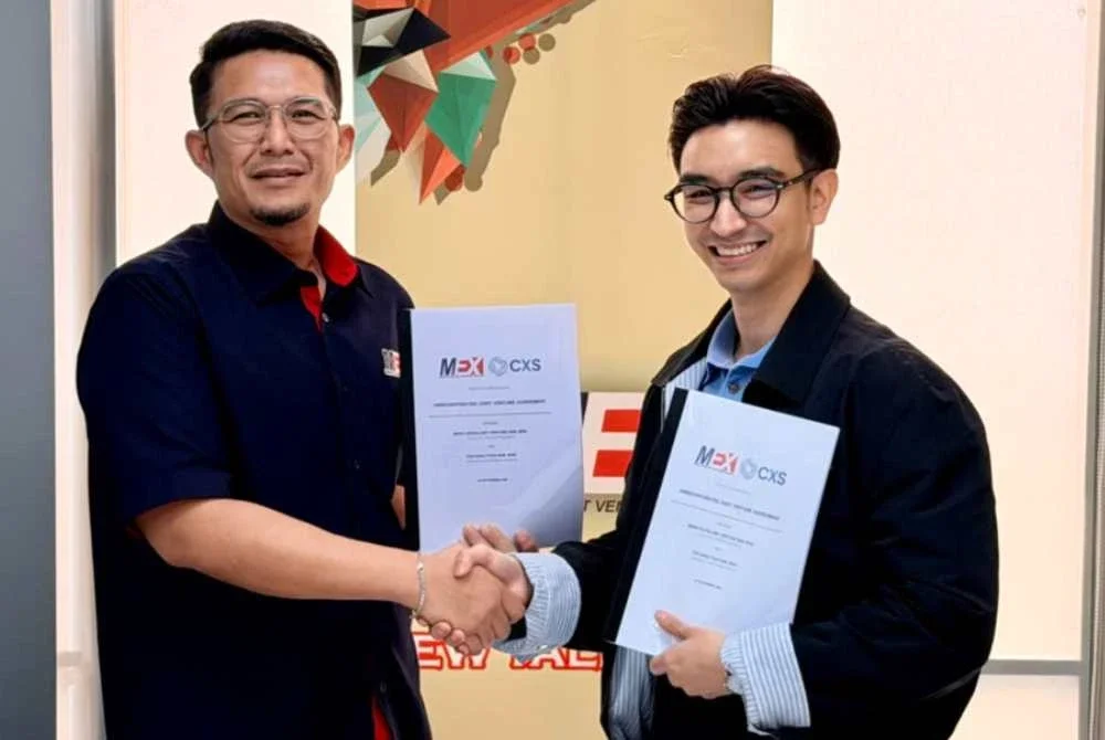 Said Harull Nizam (kiri) dan Johnathan JS bertukar dokumen pemeteraian usaha sama.