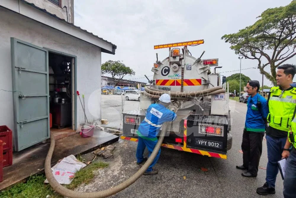 Petugas IWK bersama pegawal penguat kuasa SPAN memantau proses penyedutan enap cemar menggunakan trak tangki IWK sewaktu operasi penguatkuasaan dijalankan.