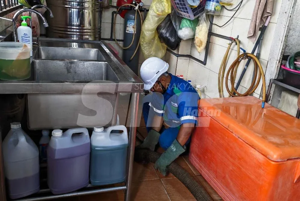 Petugas IWK sedang melakukan proses penyedutan di sebuah premis perniagaan di Taman Tas.