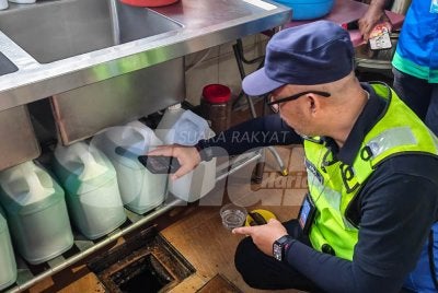 Ainal Yusman melakukan pemeriksaan secara teliti di bahagian perangkap minyak dan perangkap sisa di bawah sinki dapur sebuah premis komersial semasa Ops Tok Gajah. 