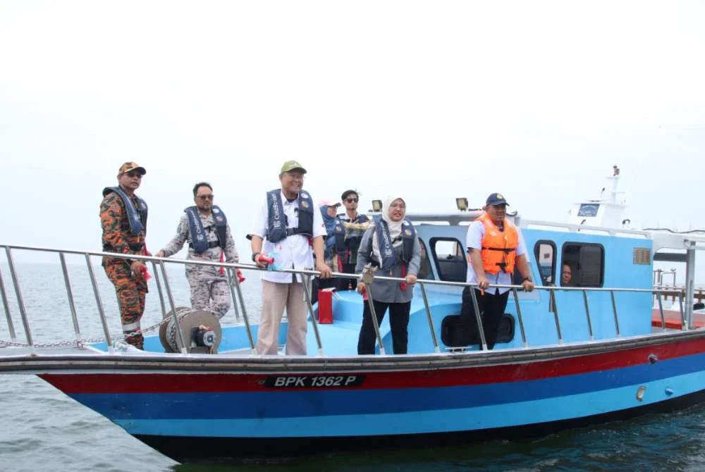 Adnan (tengah) meninjau proses melabuhkan tukun tiruan di perairan Kuala Selangor pada Rabu. Foto DOF