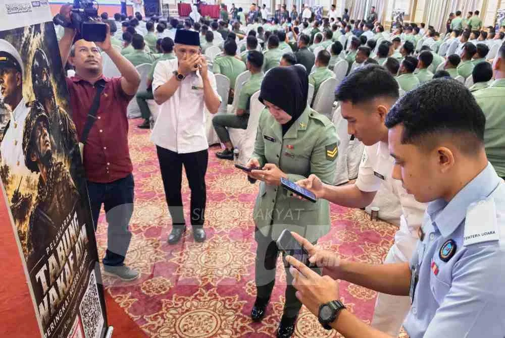 Sebahagian pegawai dan anggota ATM mengimbas kod QR pada bunting Pelancaran Tabung Wakaf ATM untuk membuat sumbangan wakaf tunai pada Majlis Penyerahan Wakalah Zakat dan Pelancaran Wakaf Tunai ATM Negeri Pahang di Kuantan pada Rabu.