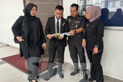 Anggota KPDN dan pihak pendakwaan melihat fail OKS.   