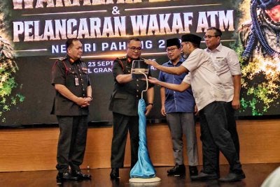 Mohd Rashidi (dua dari kiri) bersama Ahmad Hairi (tiga dari kanan) dan Mohd Azmi (kanan) menyempurnakan gimik perasmian Majlis Penyerahan Wakalah Zakat dan Pelancaran Wakaf Tunai ATM Negeri Pahang di sebuah hotel di Kuantan pada Rabu.