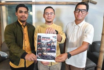 Mohd Ridhuan (tengah) bersama Ahmad Zulfikar Azlee (kiri) dan Nasaruddin (kanan) menunjukkan poster Himpunan Taufan Al-Aqsa ketika sidang akhbar di Kuala Terengganu pada Rabu.