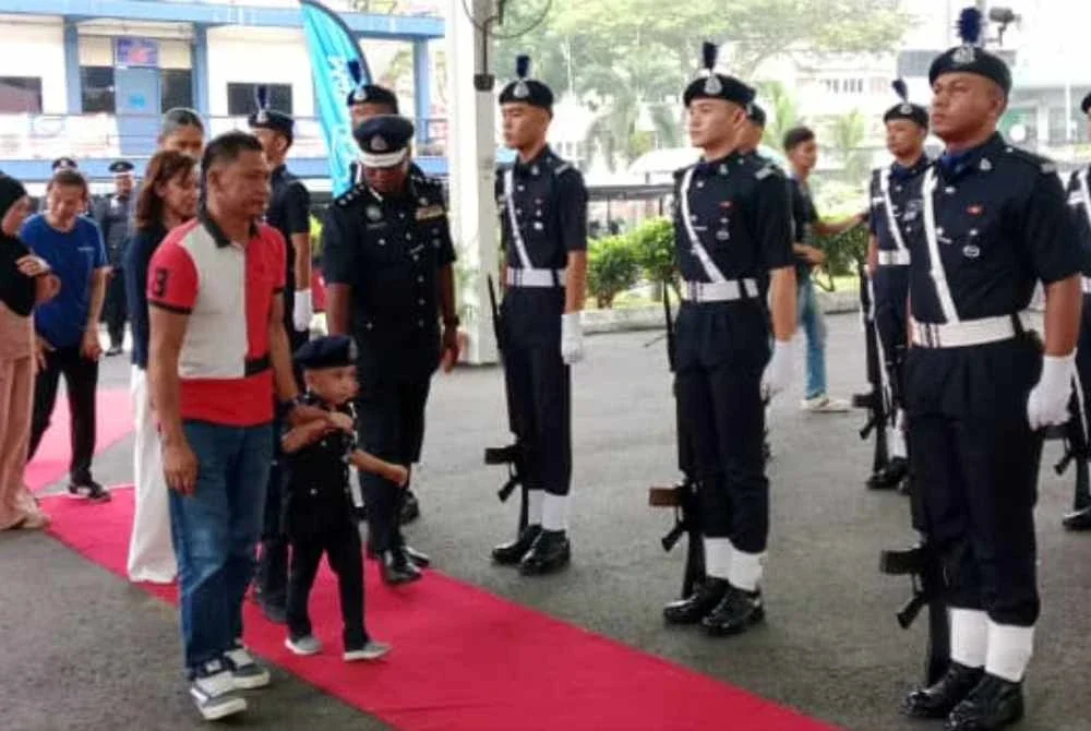 Hafiz diberikan peluang memeriksa perbarisan dalam program PDRM bersama Make A Wish Malaysia di IPD Petaling Jaya pada Khamis.