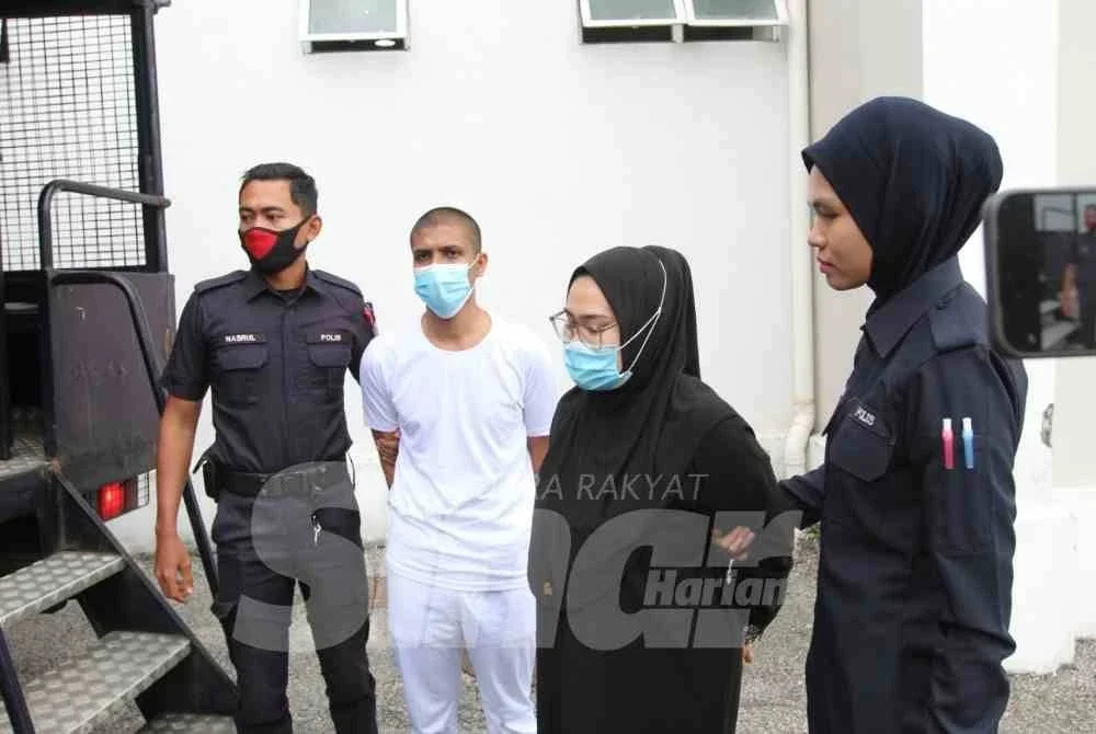 Pasangan suami isteri yang tiba di mahkamah diiringi polis sebelum mahkamah membacakan keputusan. FOTO : SINAR HARIAN / ADILA SHARINNI WAHID