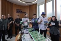 Lilis Saslinda (kanan) dan Pandak (dua dari kanan) menunjukkan produk keluaran Kampung Sungai Melayu yang mematuhi program PATUH KPDN.