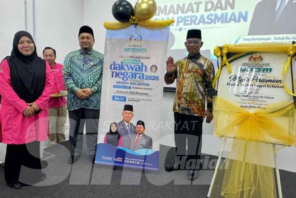 Hasan (kanan) yang menunjukkan isyarat Madani selepas merasmikan majlis di Kota Bharu. 