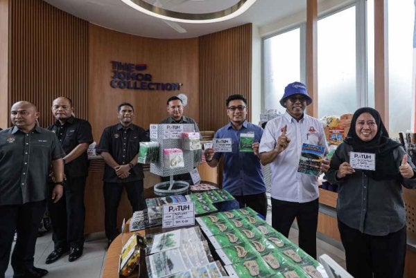 Lilis Saslinda (kanan) dan Pandak (dua dari kanan) menunjukkan produk keluaran Kampung Sungai Melayu yang mematuhi program PATUH KPDN.