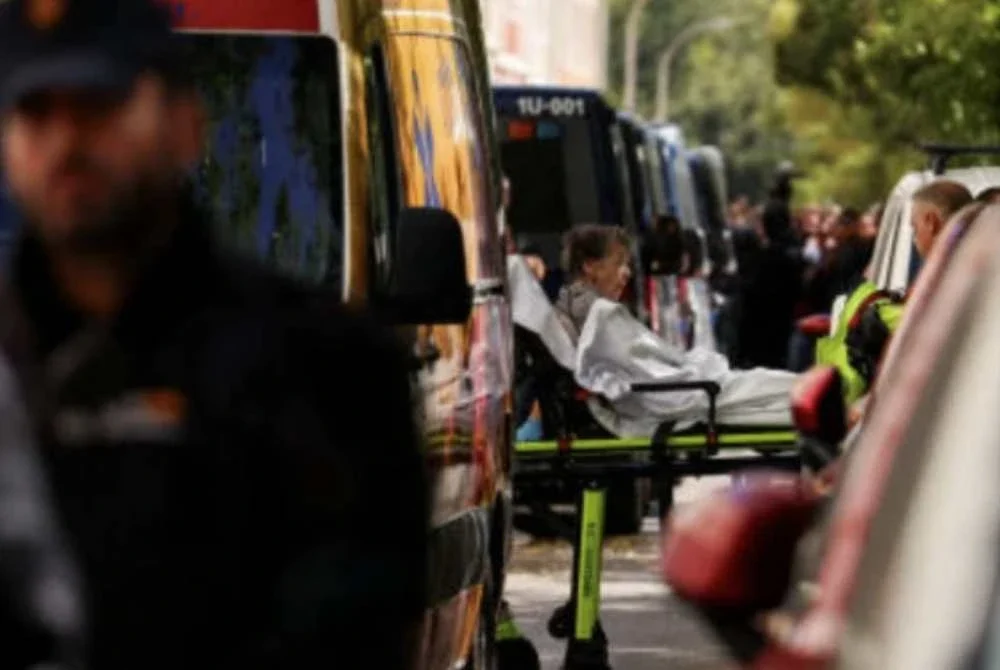 Wanita itu dibawa keluar dari rumahnya menggunakan pengusung sebelum dibawa menaiki ambulans.