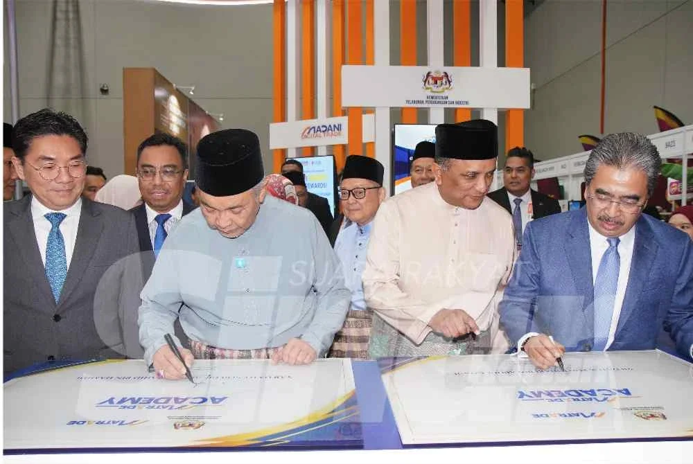 Ahmad Zahid bersama Johari menandatangani plak di reruai MATRADE ketika sesi melawat ruang pameran MIHAS 2026. Foto: SINAR HARIAN/ROSLI TALIB