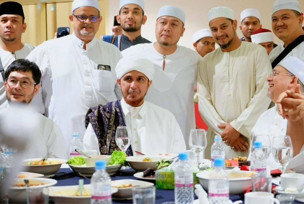 MOHAMED Shaiful Nizam (berdiri tengah) bersama ahli jawatankuasa Maulid Akbar bergambar kenangan dengan Habib Ali (duduk tengah).