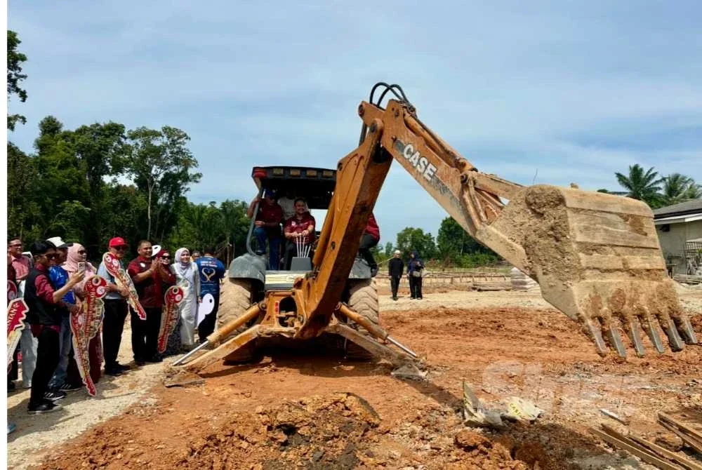 Mohamad Hafizal mengendalikan jengkaut sebagai gimik perasmian pecah tanah.