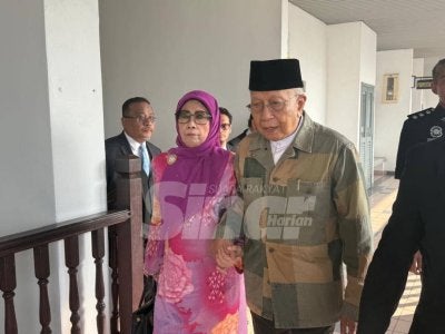 Raos ditemani Masnah tiba di Mahkamah Sesyen Ayer keroh pada Jumaat. 
