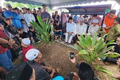 Anwar kelihatan sugul ketika pengebumian jenazah abangnya di Tanah Perkuburan Islam Masjid Cherok Tokun Bawah, Bukit Mertajam pada Jumaat.