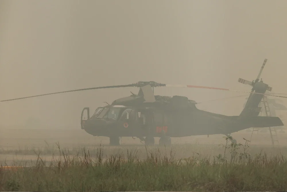 Helikopter pemadam kebakaran Black Hawk milik BNPB berada di landasan Lapangan Terbang Tjilik Riwut, Palangkaraya, Kalimantan Tengah, diselubungi jerebu akibat kebakaran hutan. Foto: AFP, Agensi