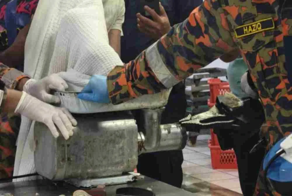 Anggota bomba menjalankan operasi menyelamat bagi mengeluarkan tangan mangsa yang tersepit dalam mesin pengisar daging di sebuah kilang pemprosesan ayam, di Bercham, Ipoh pada Sabtu. Foto JBPM Perak
