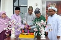Takiyuddin (tengah) memotong pulut kuning sempena karnival yang diadakan di Lembah Sireh di Kota Bharu pada Sabtu. Foto: ADILA SHARINNI WAHID
