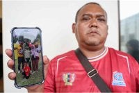 Kamaruddin menunjukkan gambar anak saudaranya bersama ibu bapa ketika ditemui media di Unit Forensik Hospital Tuanku Ja’afar, Seremban pada Sabtu