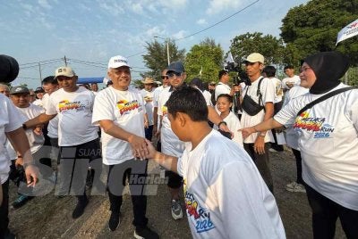 Hamzah beramah mesra bersama peserta Melaka Coastal Run pada Sabtu.