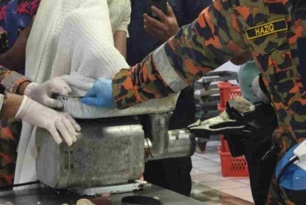 Anggota bomba menjalankan operasi menyelamat bagi mengeluarkan tangan mangsa yang tersepit dalam mesin pengisar daging di sebuah kilang pemprosesan ayam, di Bercham, Ipoh pada Sabtu. Foto JBPM Perak 