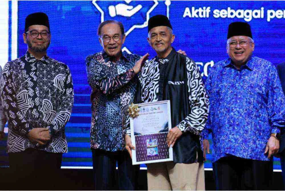 Perdana Menteri Datuk Seri Anwar Ibrahim (dua, kiri) menyampaikan Anugerah Tokoh Ummah kepada Mohd Annuar Mohd Salleh (dua, kanan) semasa hadir ke Majlis Makan Malam Apresiasi 3 Generasi (WADAH, ABIM, PKPIM) di Pusat Konvensyen Bangi Avenue malam ini. Foto Bernama