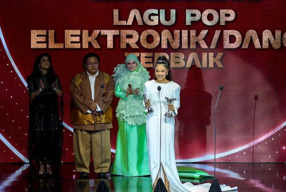 Mimi Fly (kanan) tersenyum ceria selepas dinobatkan sebagai pemenang anugerah Lagu Pop Elektronik/Dance Terbaik pada malam Anugerah Industri Muzik (AIM) ke-25 yang berlangsung meriah di Pusat Konvensyen Borneo Kuching. Foto Bernama