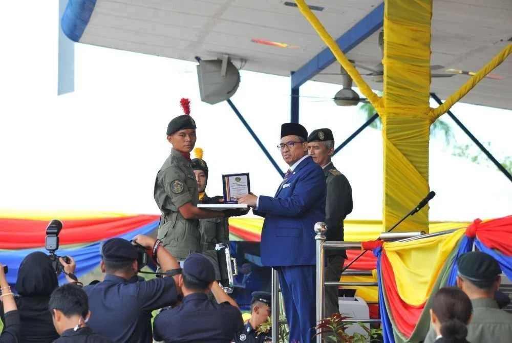 Shamsul Azri (kanan) menyampaikan Anugerah Terbaik Keseluruhan Kursus Asas Pegawai AKPS.