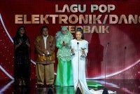 Mimi Fly (kanan) tersenyum ceria selepas dinobatkan sebagai pemenang anugerah Lagu Pop Elektronik/Dance Terbaik pada malam Anugerah Industri Muzik (AIM) ke-25 yang berlangsung meriah di Pusat Konvensyen Borneo Kuching. Foto Bernama 