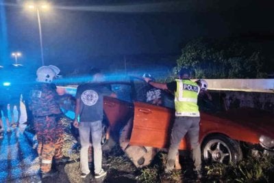 Sebuah kereta jenis Proton Gen2 yang terbabas sebelum melanggar pembahagi jalan di Jalan Persekutuan Trolak Pekan, Slim River pada Ahad. Foto JBPM Perak