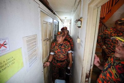 Nor Mahathir (tengah) melakukan pemeriksaan ke atas sebuah bangunan yang diubah suai menjadi bilik menerusi Operasi Bersepadu Pemeriksaan Premis 'Sarang Burung' di sekitar bandar raya Kuala Terengganu pada Ahad. Foto Bernama