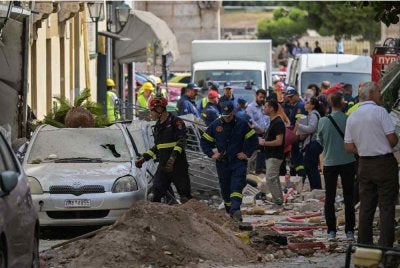 Pasukan penyelamat menjalankan tugas di lokasi sebuah bangunan lama yang runtuh sebahagiannya susulan satu letupan di kawasan Plaka, pusat bandar Athens pada 25 September 2026 - Foto: AFP