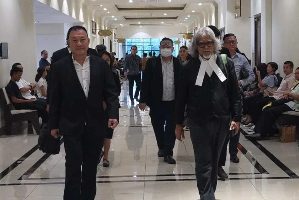 Tze Khen (kiri) bersama peguamnya, Ram ketika hadir ke Mahkamah Kota Kinabalu.